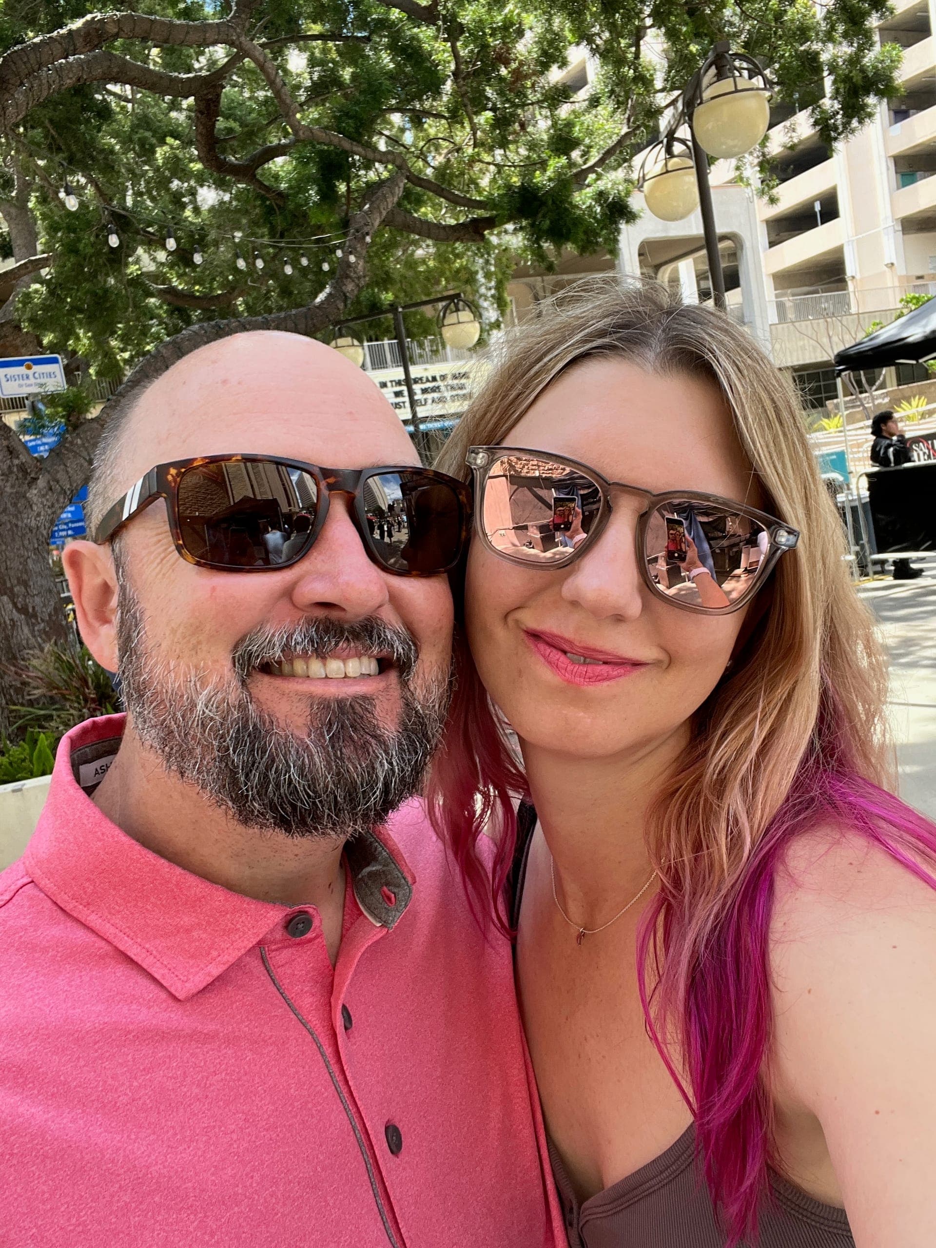 Selfie of Sarah and Erik in sunglasses on a sunny day outside the Civic Theater in downtown San Diego.