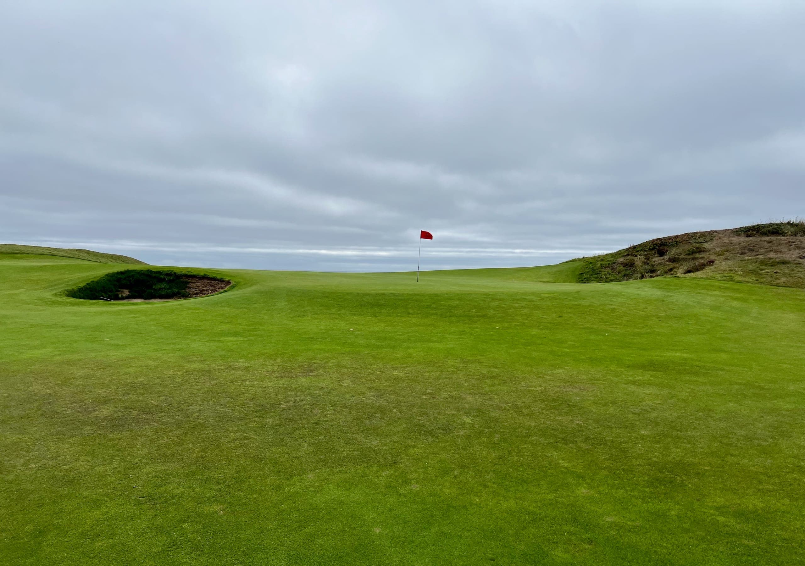 Large undulating greens on hole number 12 at Bandon Dunes with the ocean in the background.