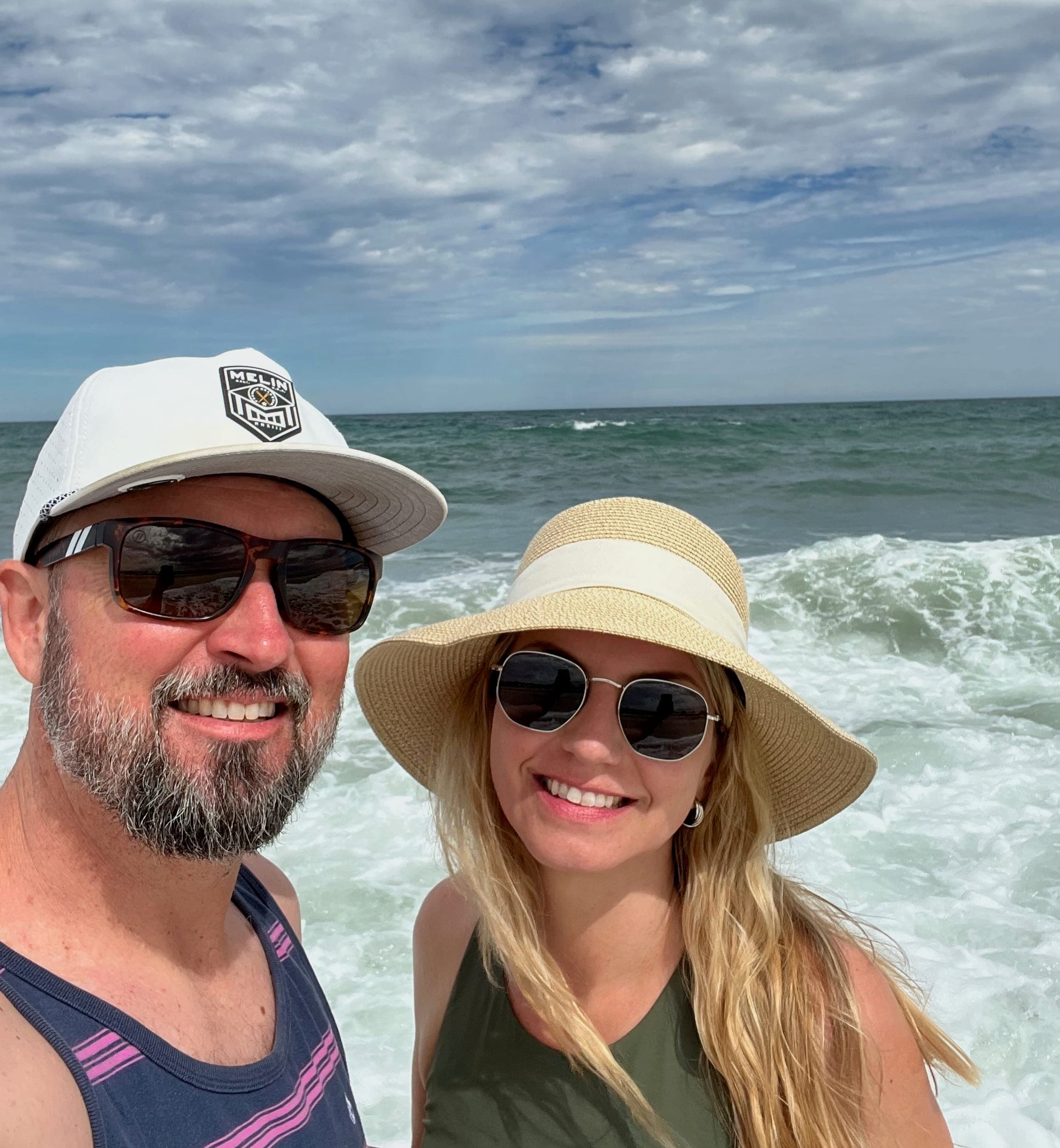 Selfie of Erik and Sarah at the beach in Mexico with the ocean waves in the background.