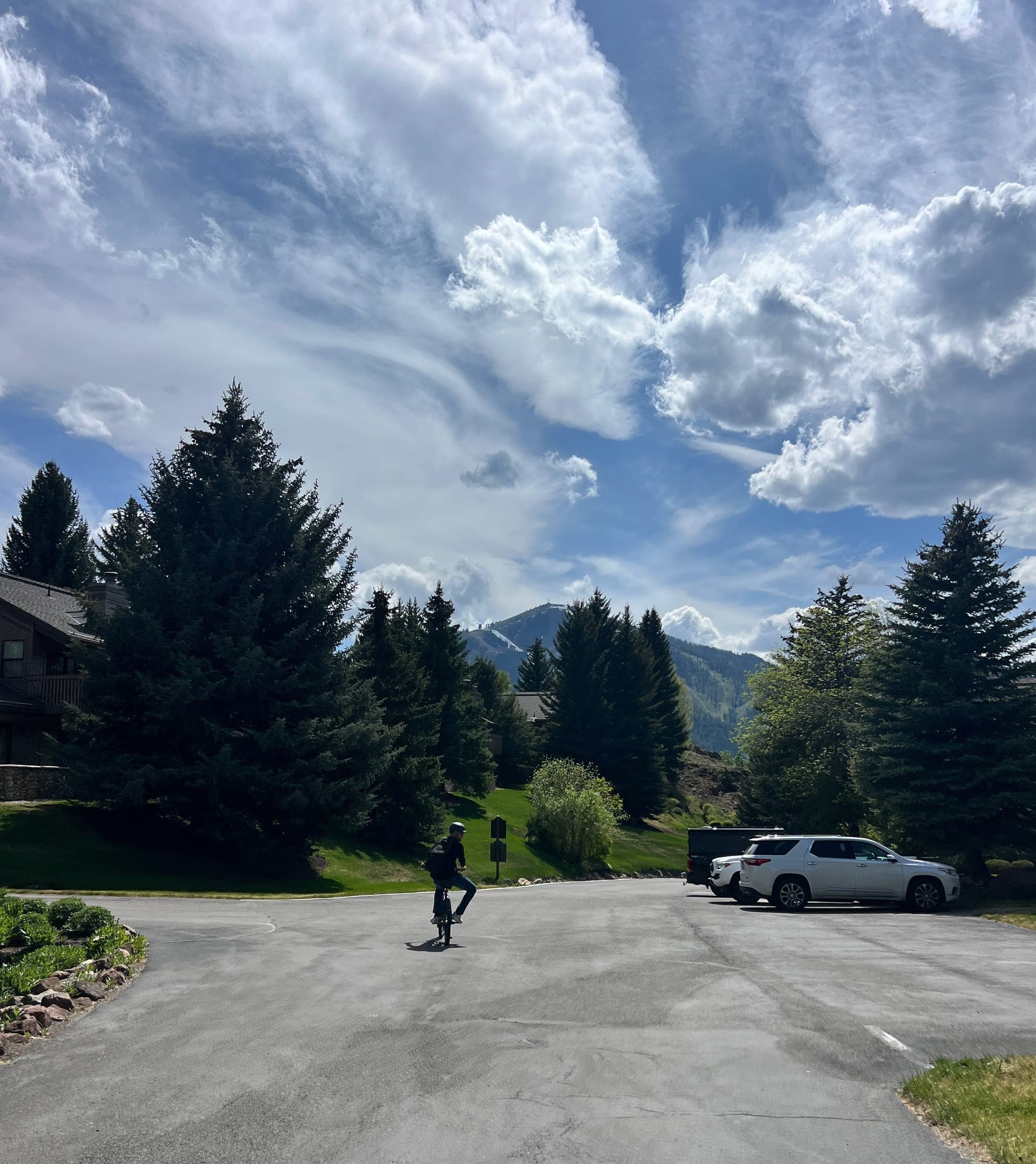Erik riding a bike down a neighborhood road with Bald Mountain in the background.