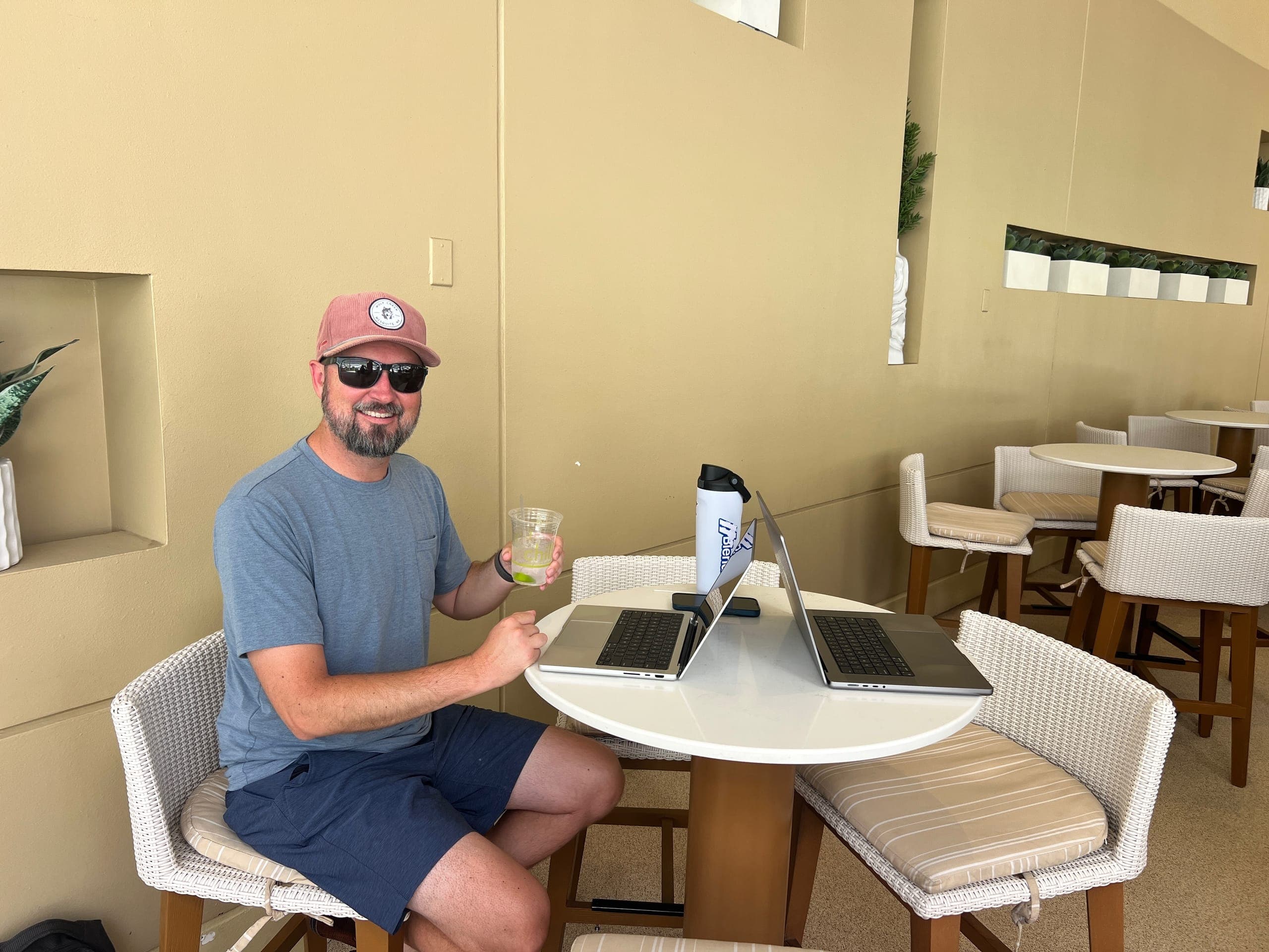 Erik with his laptop working hard at a poolside table.