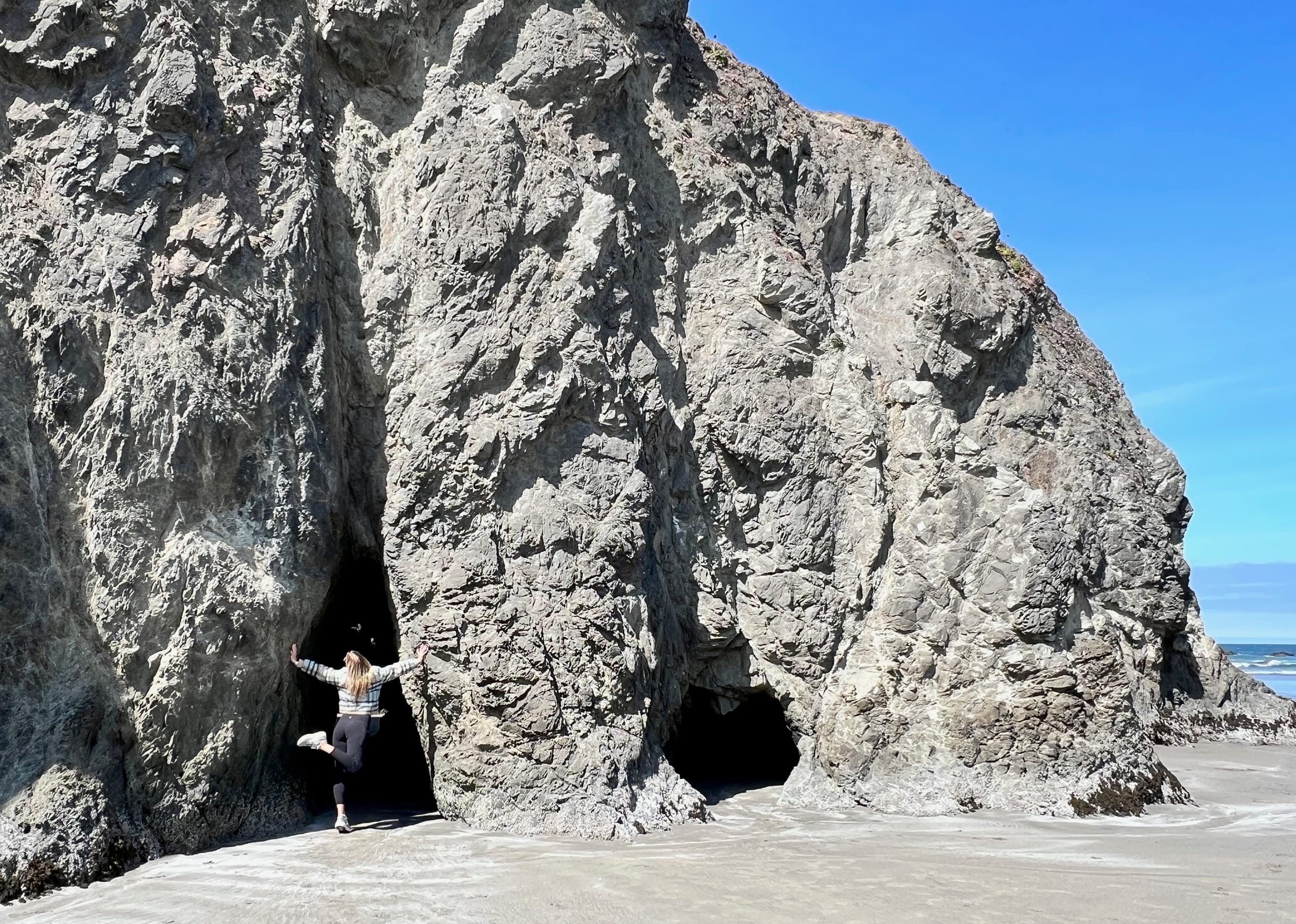Sarah posing in front of a gap in the coastal rocks.