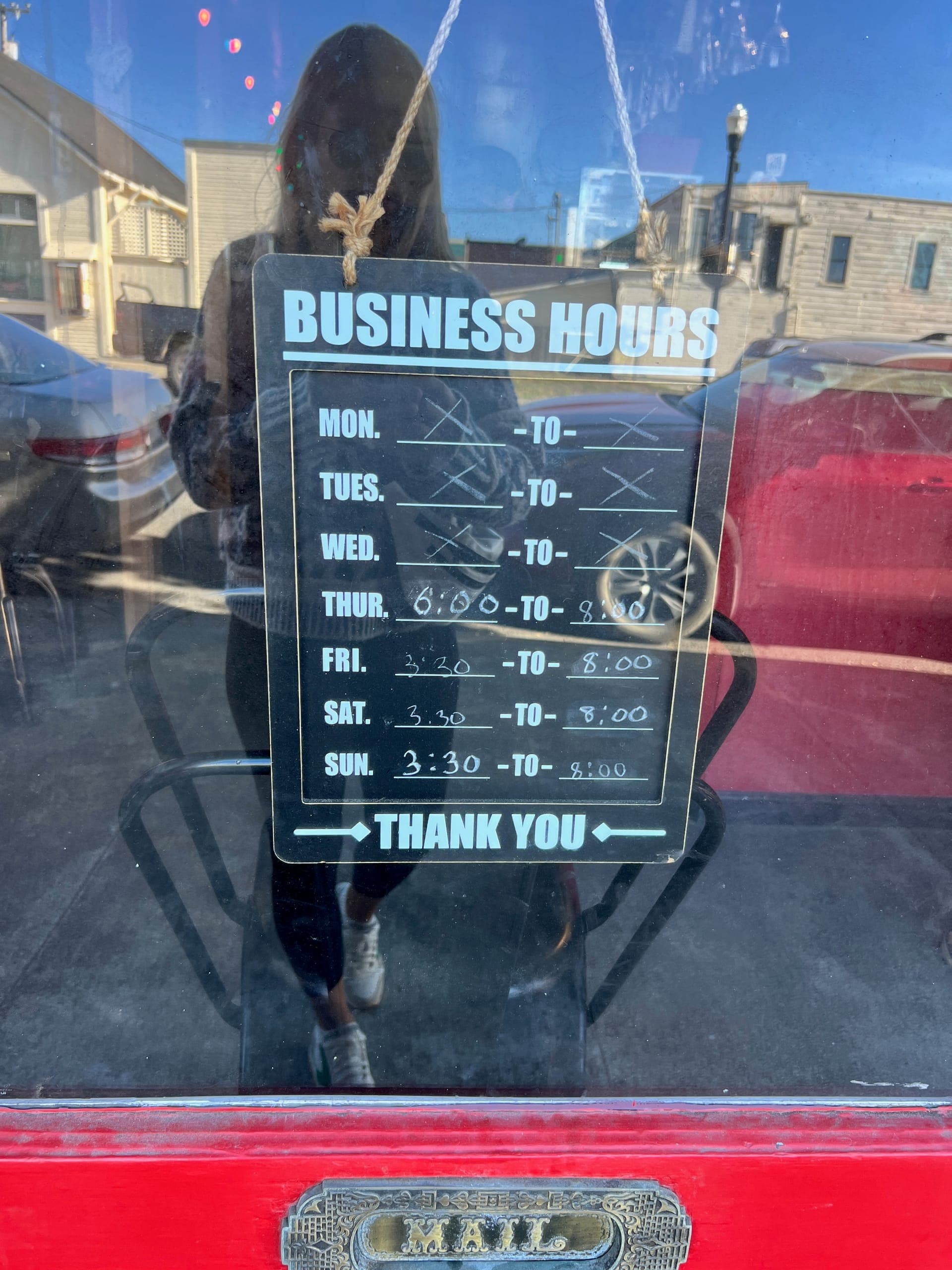 Hours sign hanging on the door of a restaurant that shows they are only open a few hours a week.